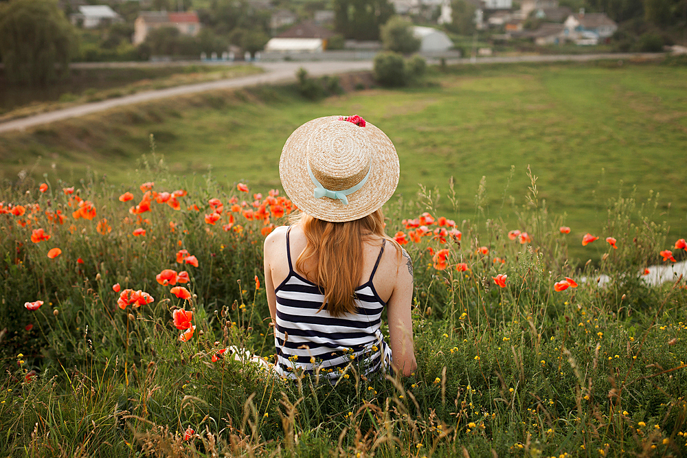 Caucasian woman sitting in wildflowers