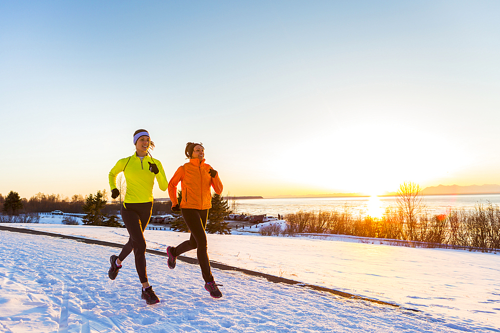 Women running on snow in winter