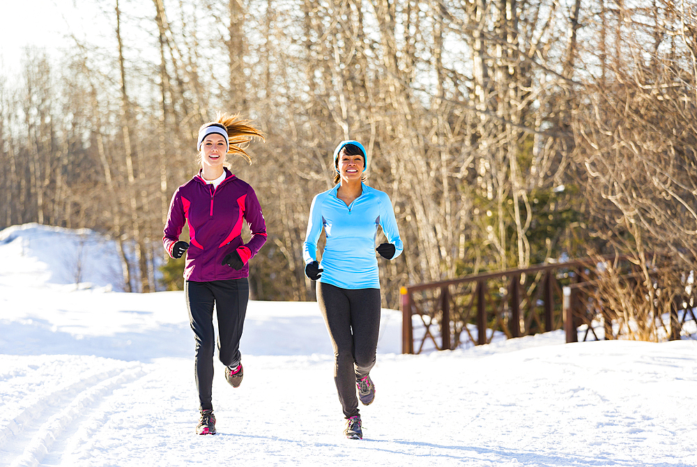 Women running on snow in winter