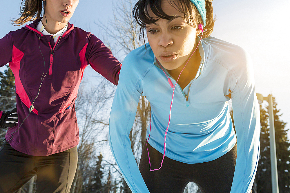 Runners listening to earbuds and resting