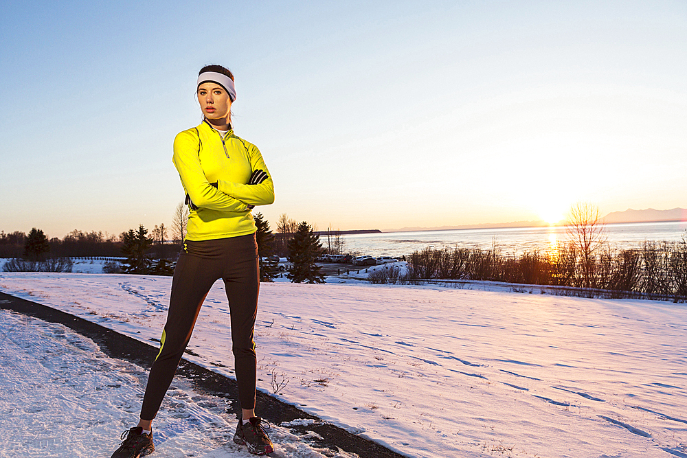 Caucasian runner posing with arms crossed in winter