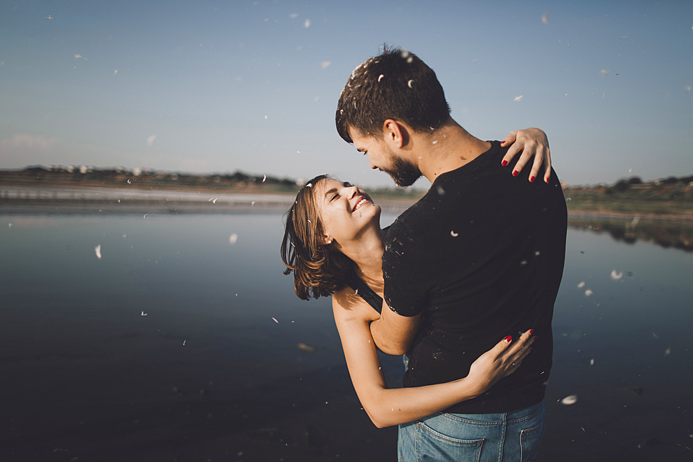 Caucasian couple hugging at lake