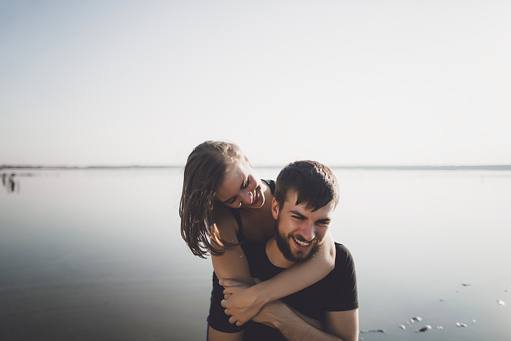 Caucasian couple hugging near lake