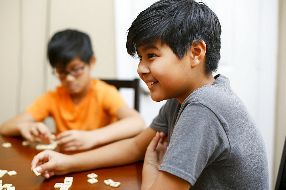 Native American boys playing spelling game at table