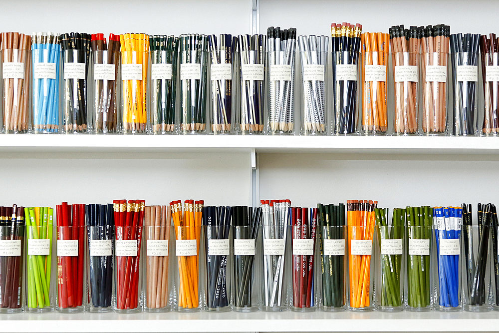 Variety of pencils in cups on store shelves