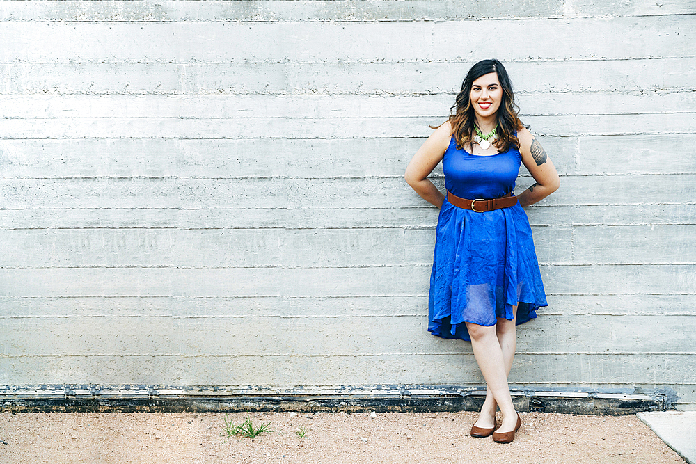 Portrait of smiling Mixed Race woman leaning on wall