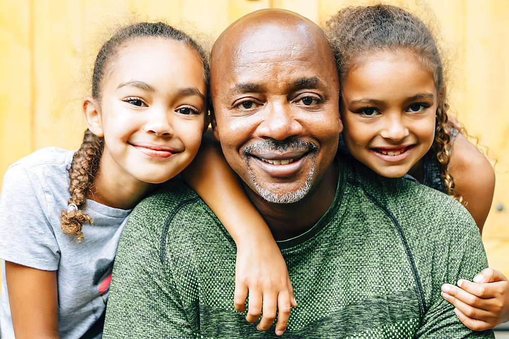 Portrait of smiling father and daughters