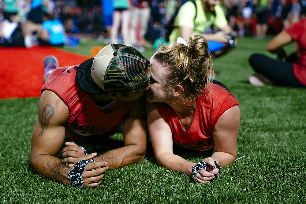 Man and woman laying on artificial turf and kissing