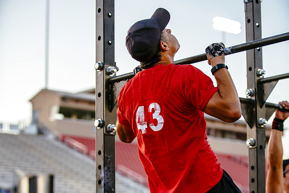 Caucasian man doing chin-ups outdoors