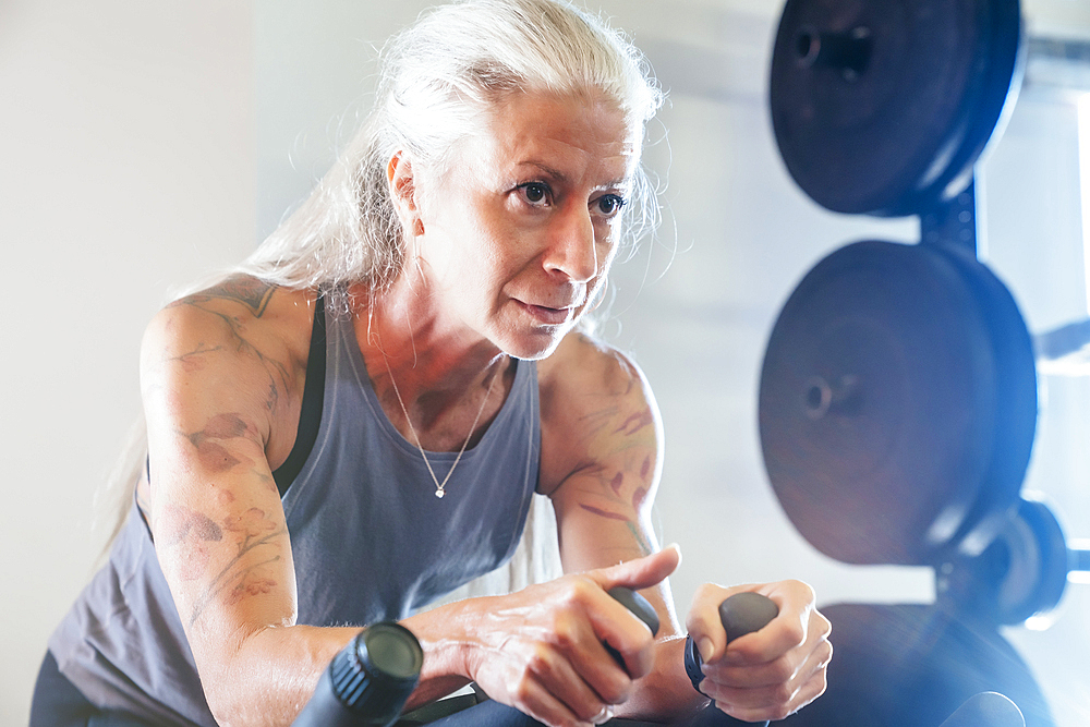 Caucasian woman riding stationary bicycle