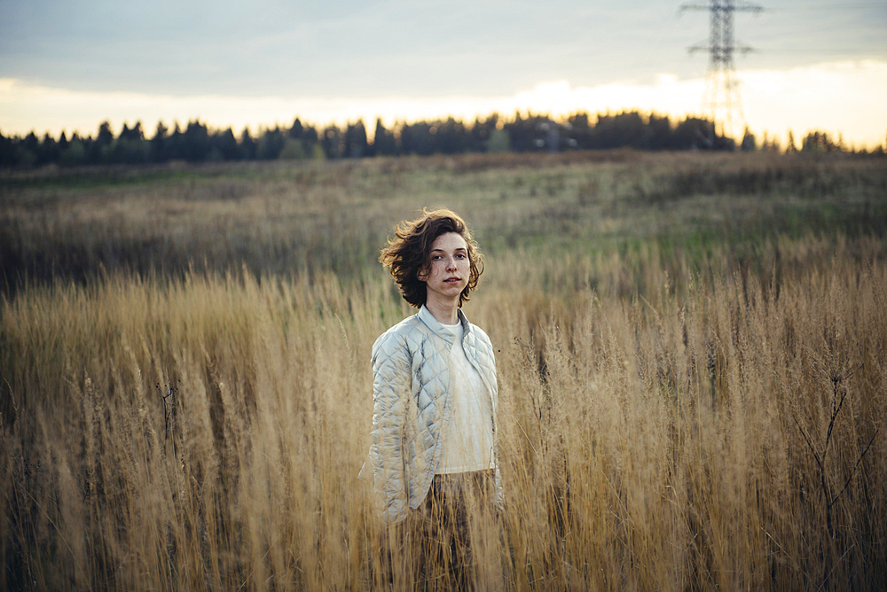 Caucasian woman standing in field of tall grass