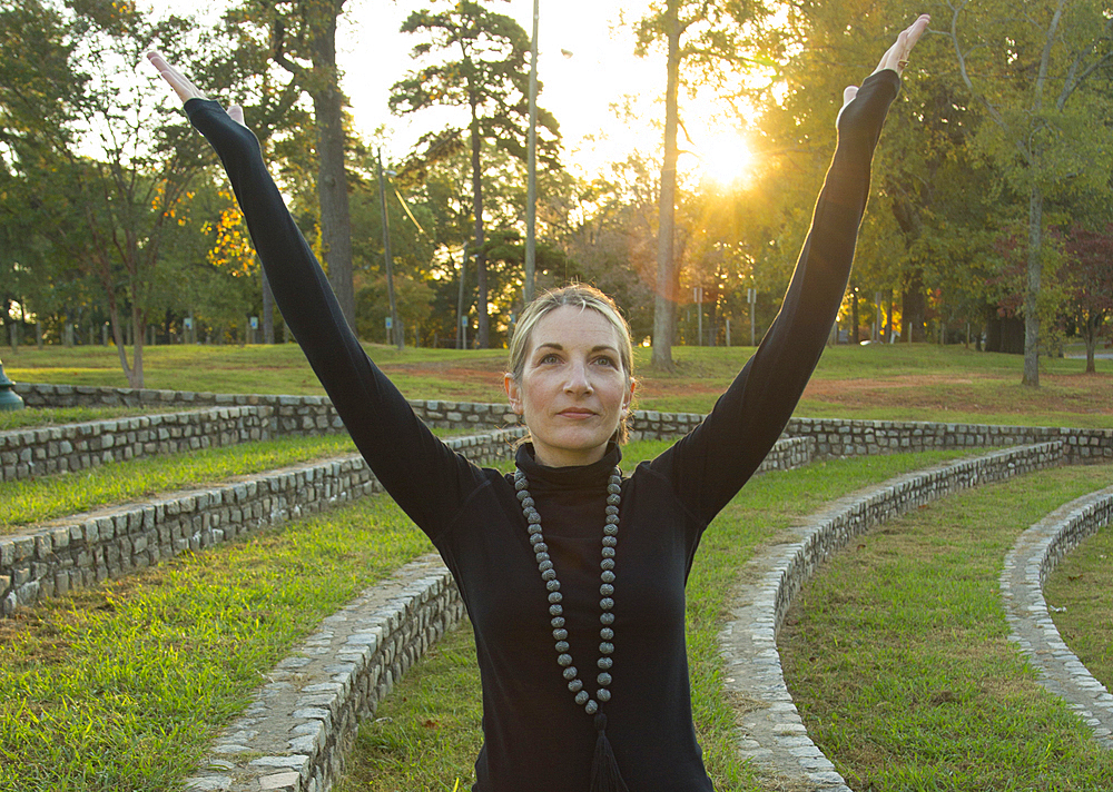 Caucasian woman meditating in park