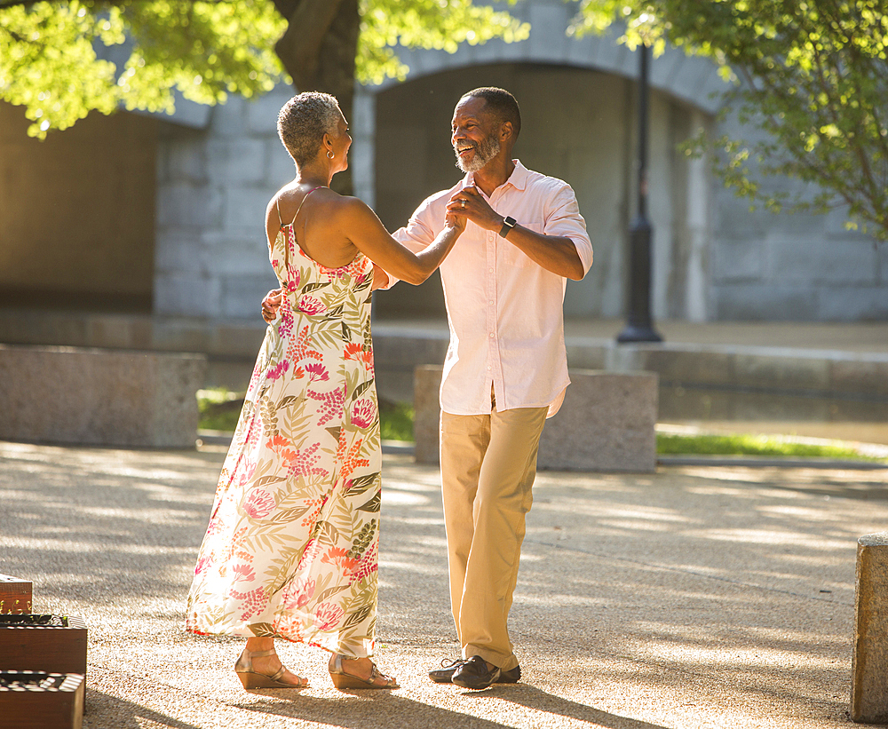 Black couple dancing in park