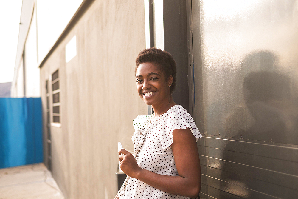 Smiling African American woman holding cell phone