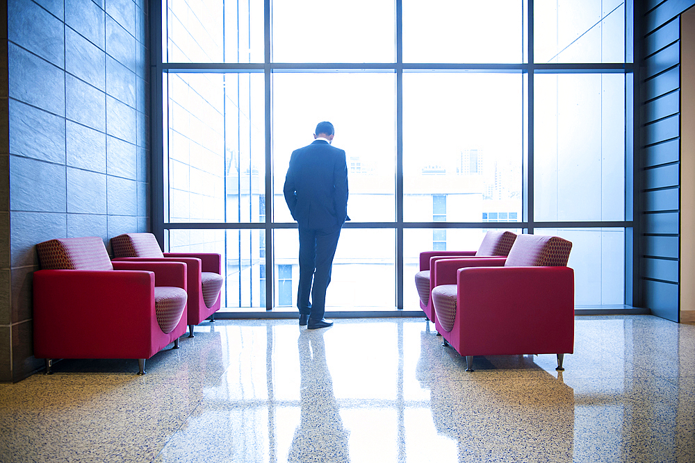 Hispanic businessman waiting in office lounge near window