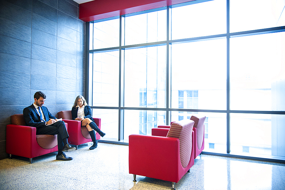 Businessman and businesswoman sitting in office lounge