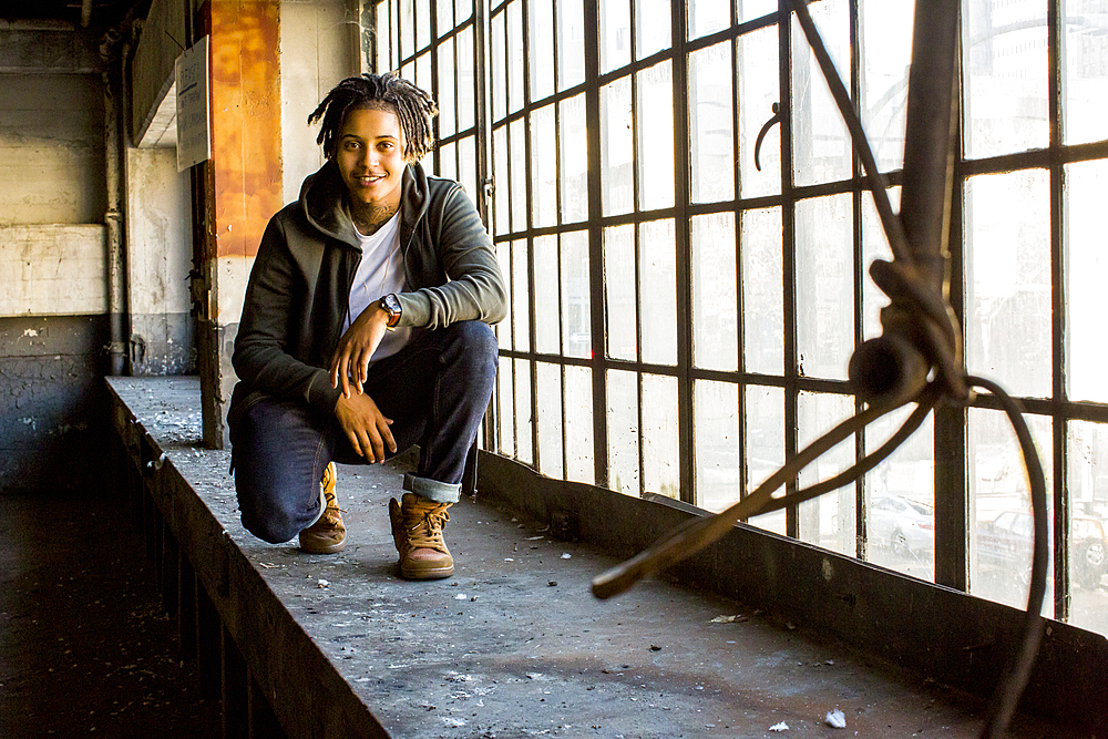 Androgynous Mixed Race woman smiling near window