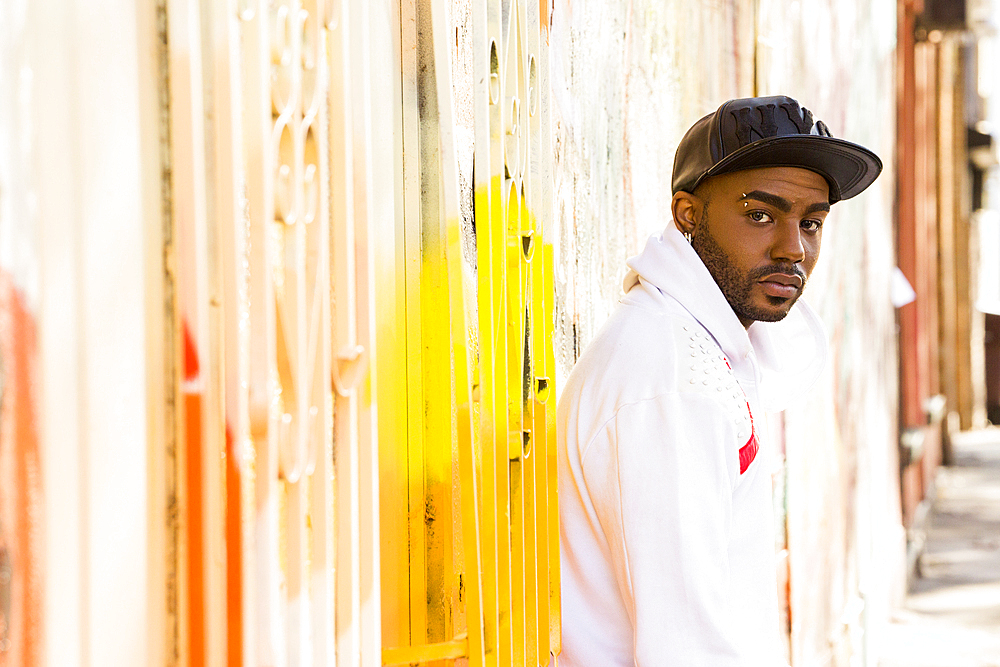 Serious Black man standing near gate