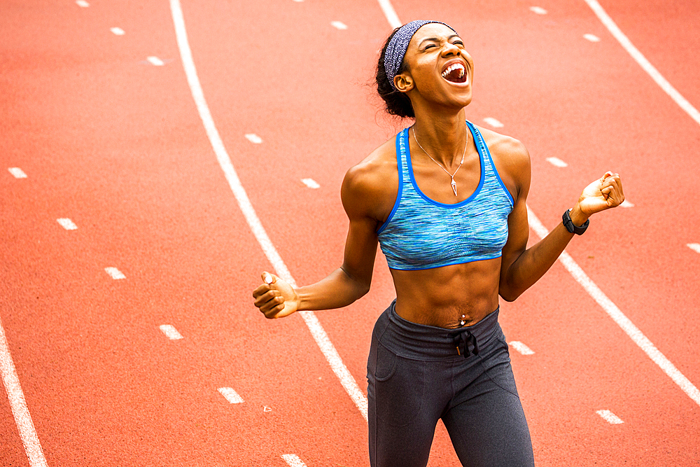 Happy Black athlete celebrating on track