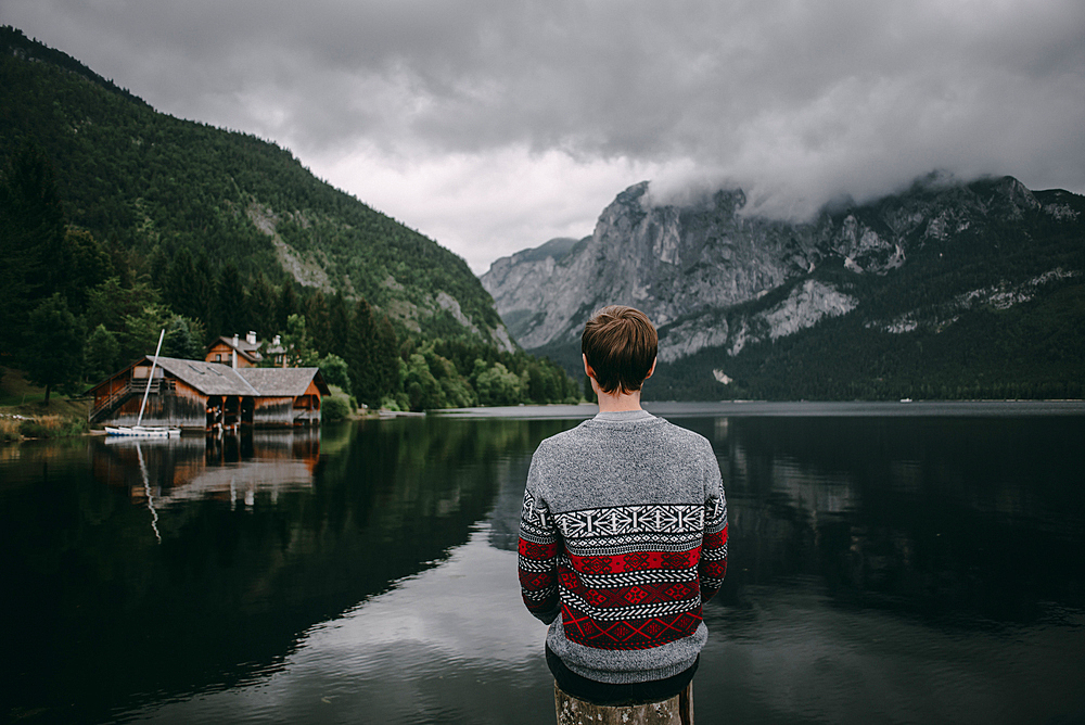 Caucasian man sitting on post admiring scenic view of mountain