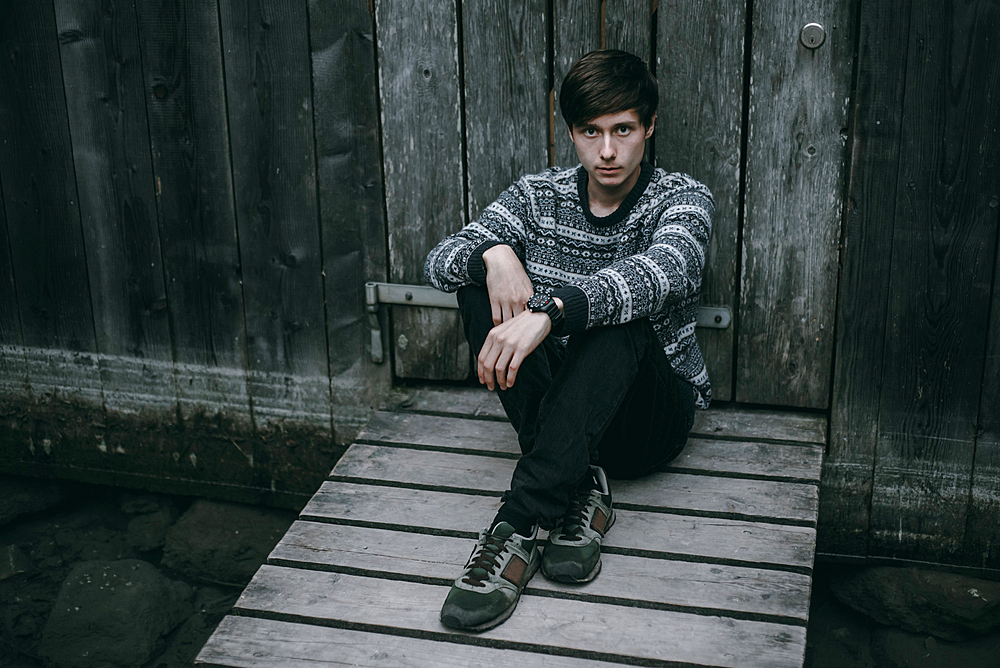 Caucasian man sitting on wooden dock