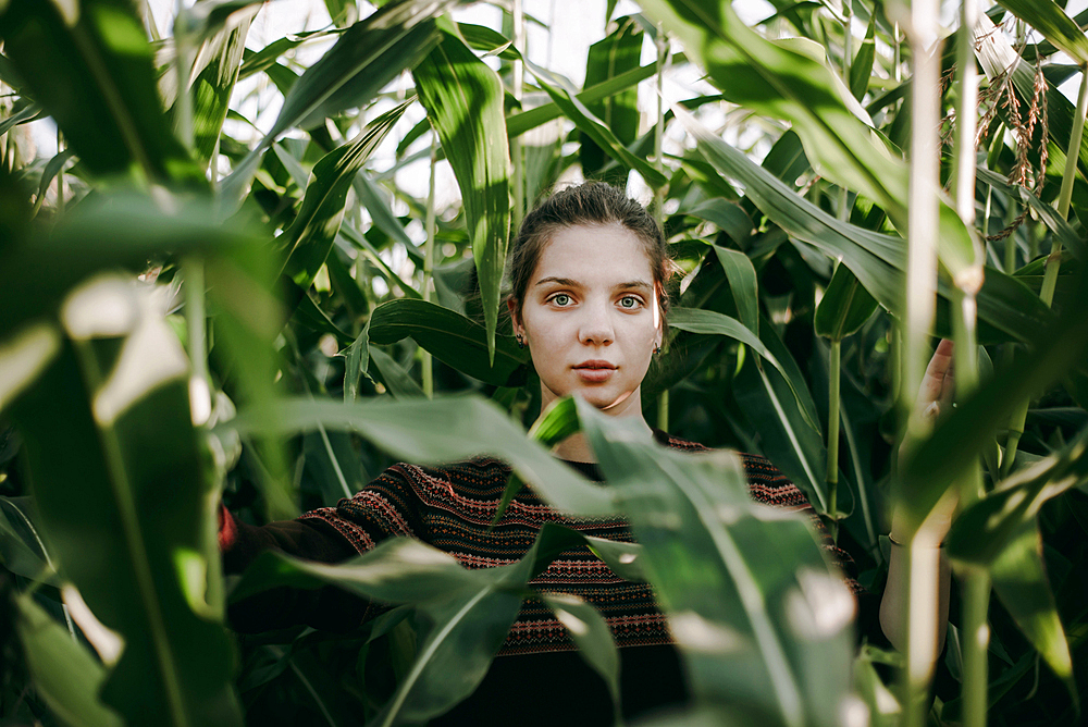 Caucasian woman standing in tall corn field