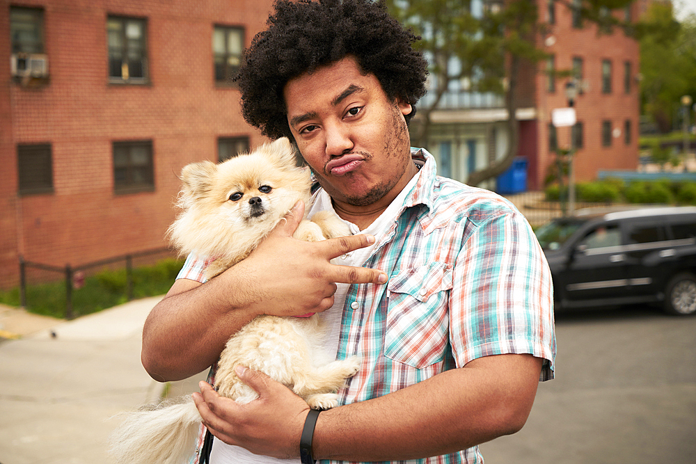 Mixed Race man gesturing peace with dog in city