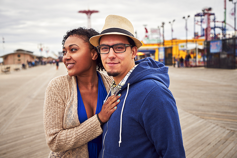 Couple standing on boardwalk at amusement park