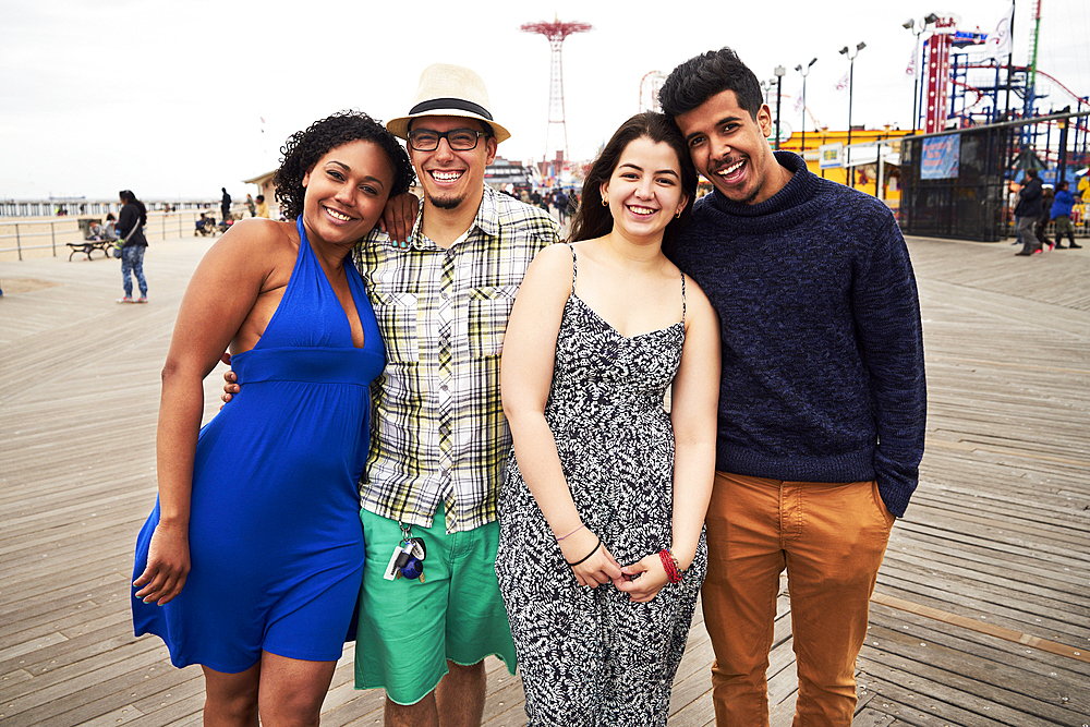 Friends posing on boardwalk at amusement park