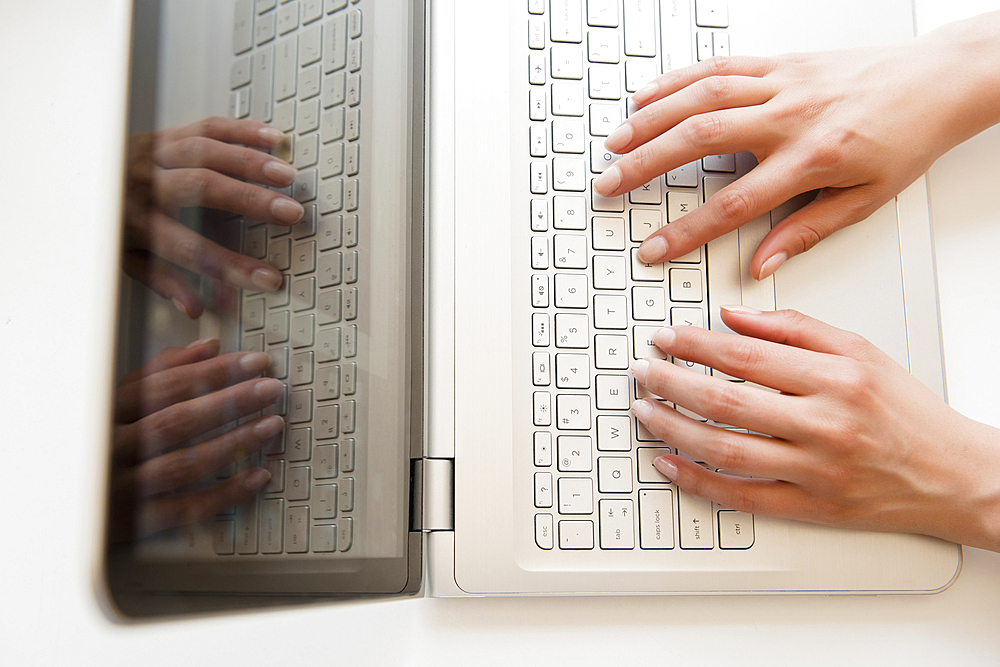 Hands of Hispanic woman typing on laptop