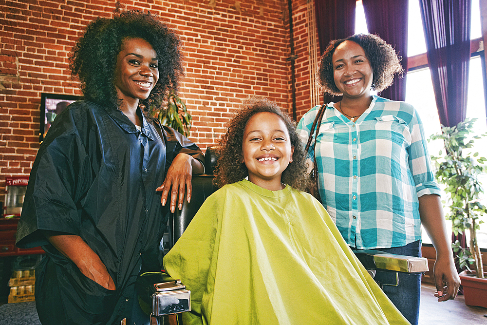 Smiling hairdresser and customers in hair salon