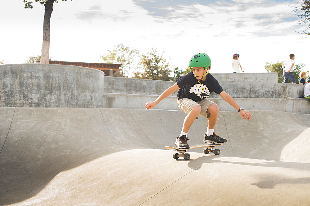 Mixed Race boy skateboarding in skate park