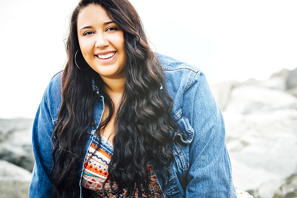 Smiling Mixed Race woman near ocean