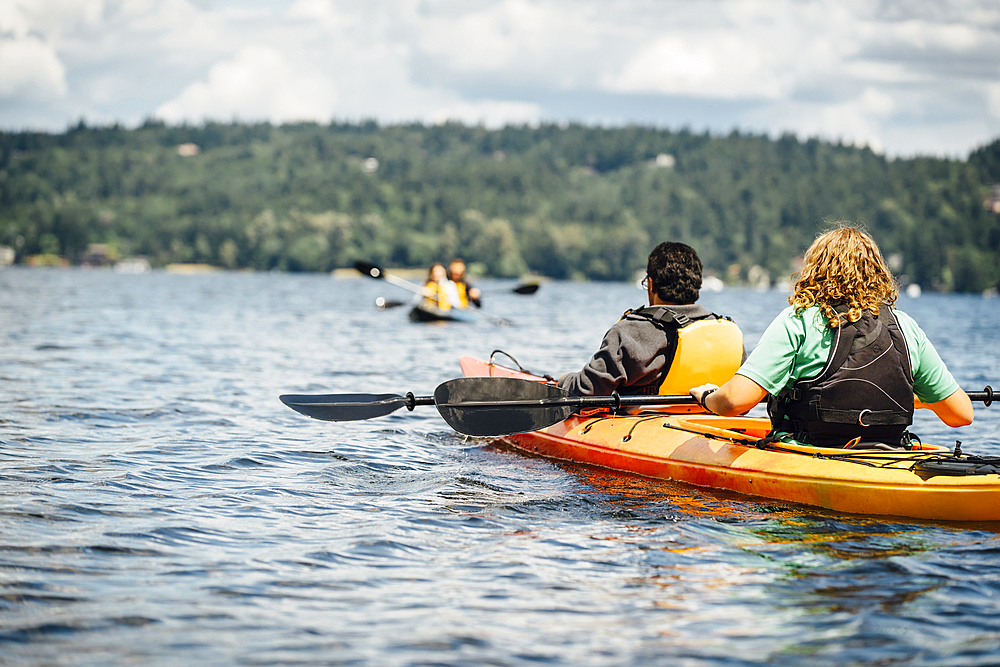 Man and woman holding paddles in kayak