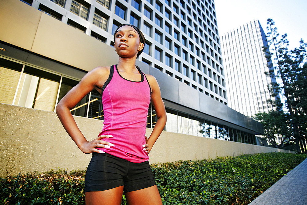 Serious Black woman standing on city sidewalk