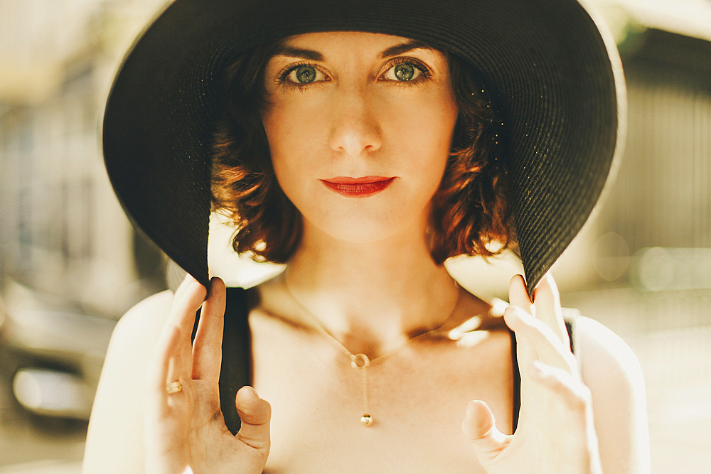 Glamorous Caucasian woman holding hat