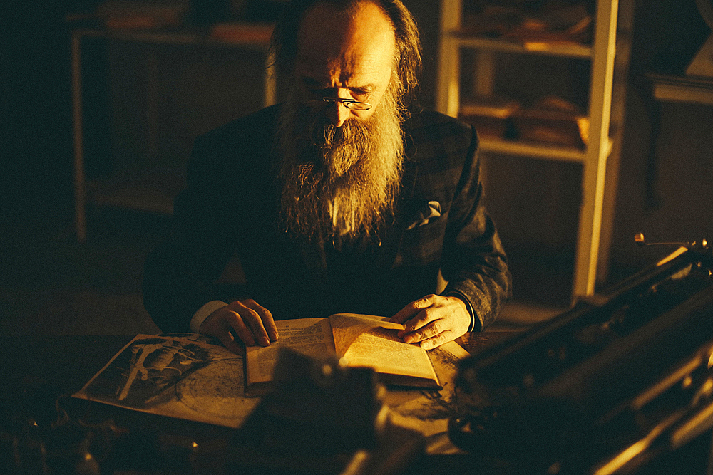 Caucasian man with beard reading book