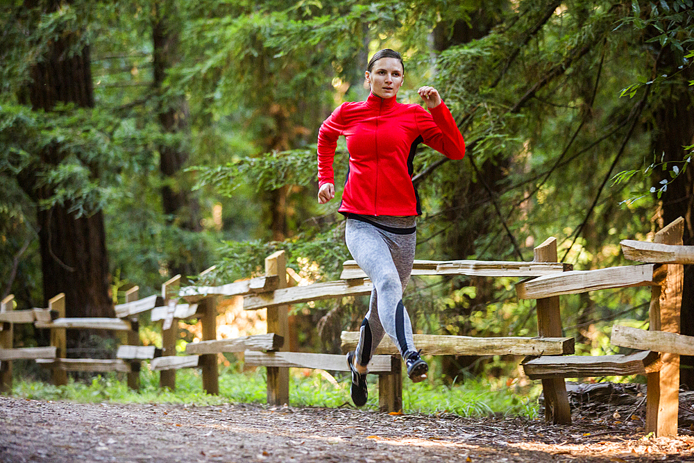 Woman running on forest path