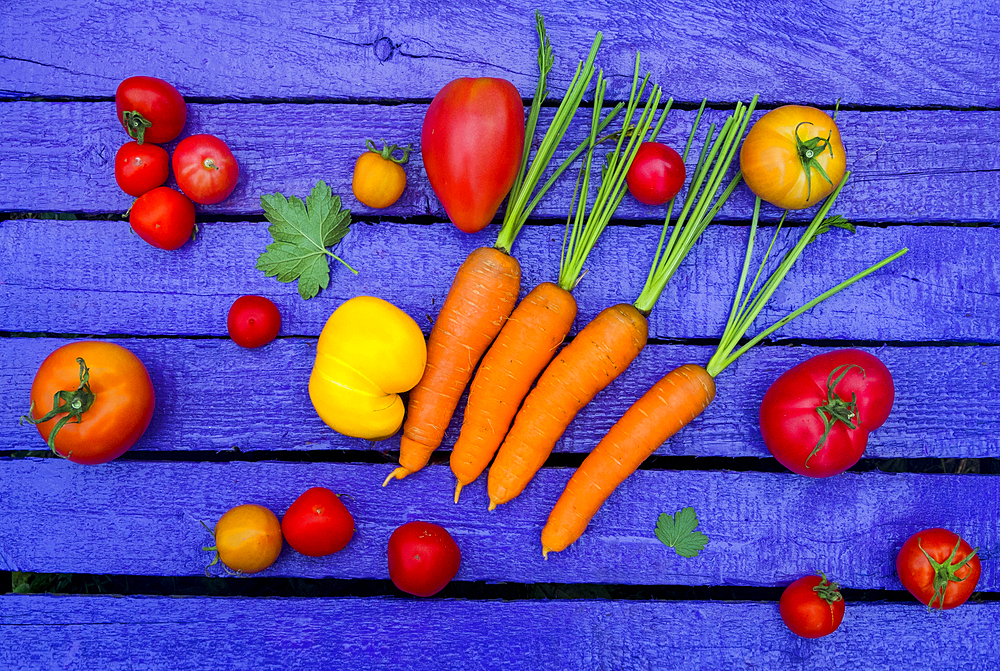 Fresh vegetables on purple wooden table