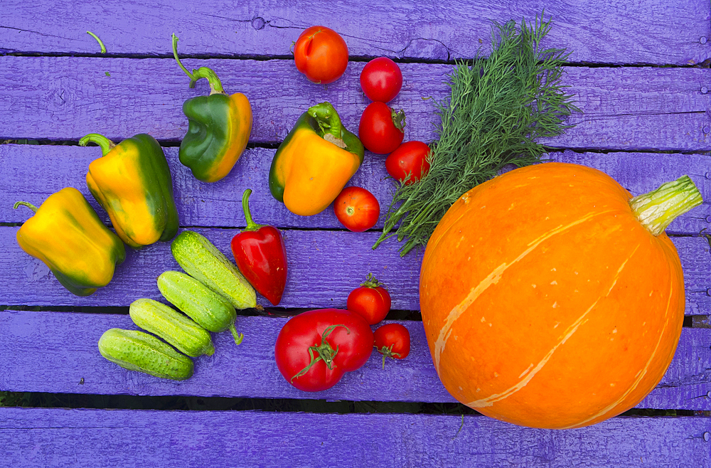 Fresh vegetables on purple wooden table