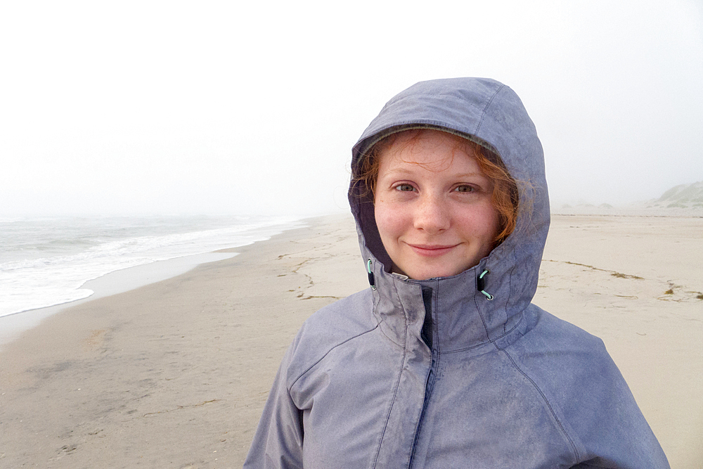 Portrait of smiling Caucasian girl on cold beach