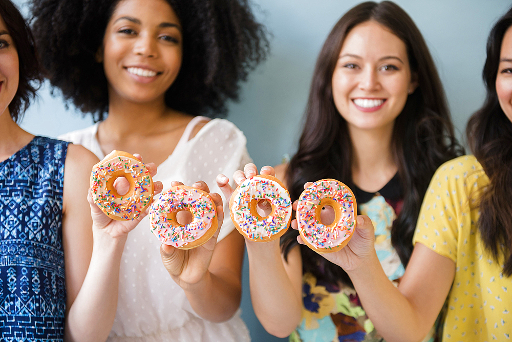 Portrait of smiling women posing with donuts