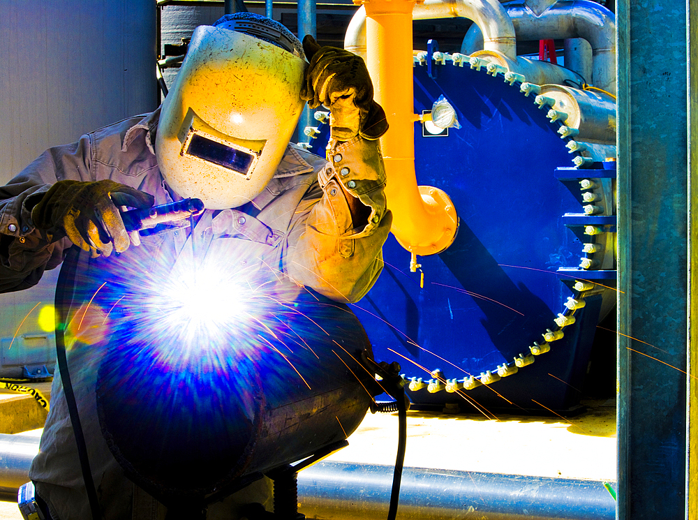 Caucasian welder working in factory