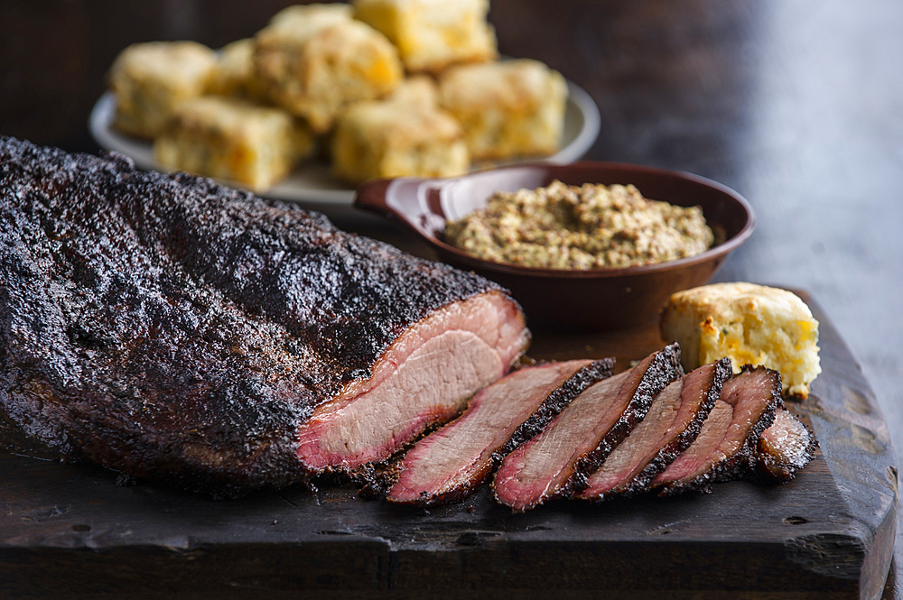 Sliced brisket and biscuits on cutting board