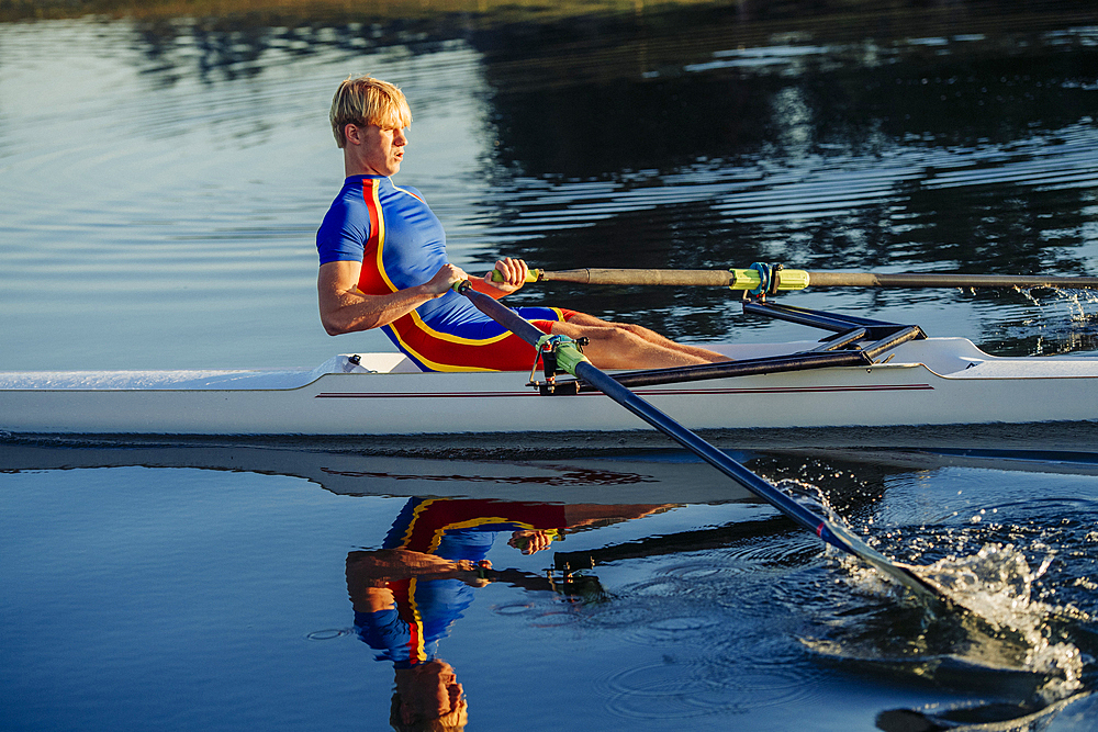 Caucasian man rowing on river