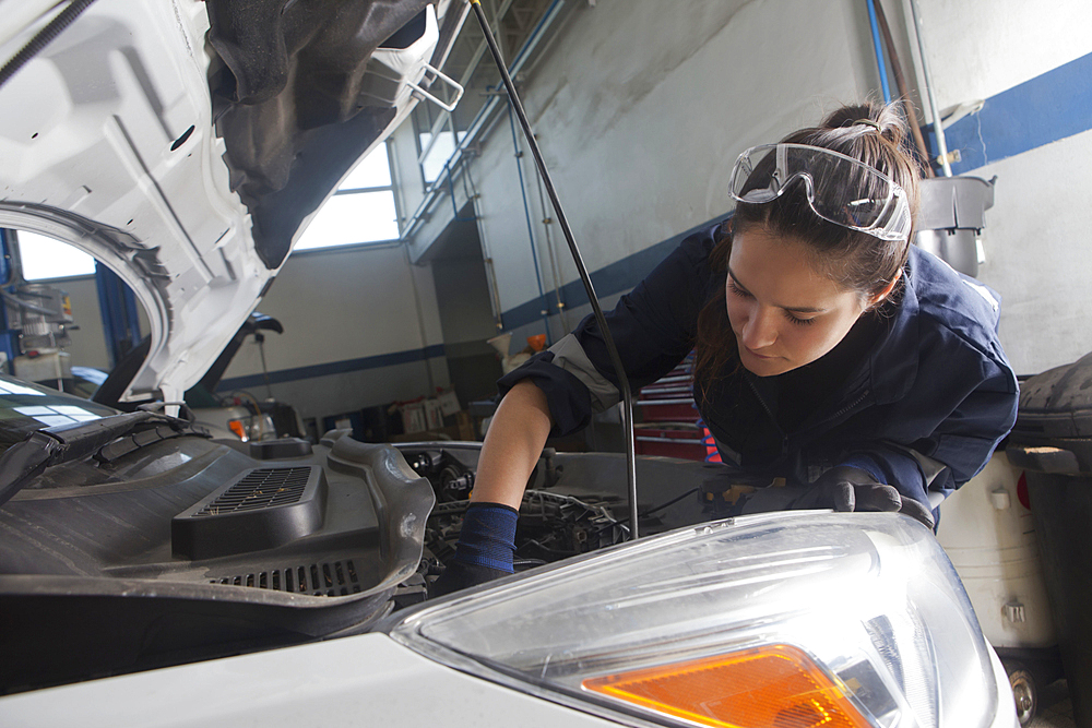 Hispanic mechanic repairing car engine