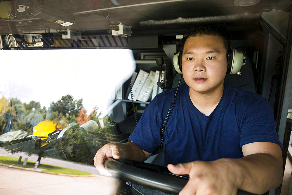 Chinese fireman wearing headphones driving fire truck