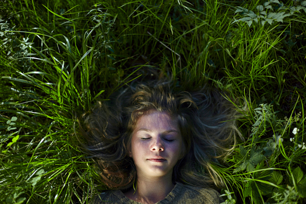 Caucasian girl laying in grass