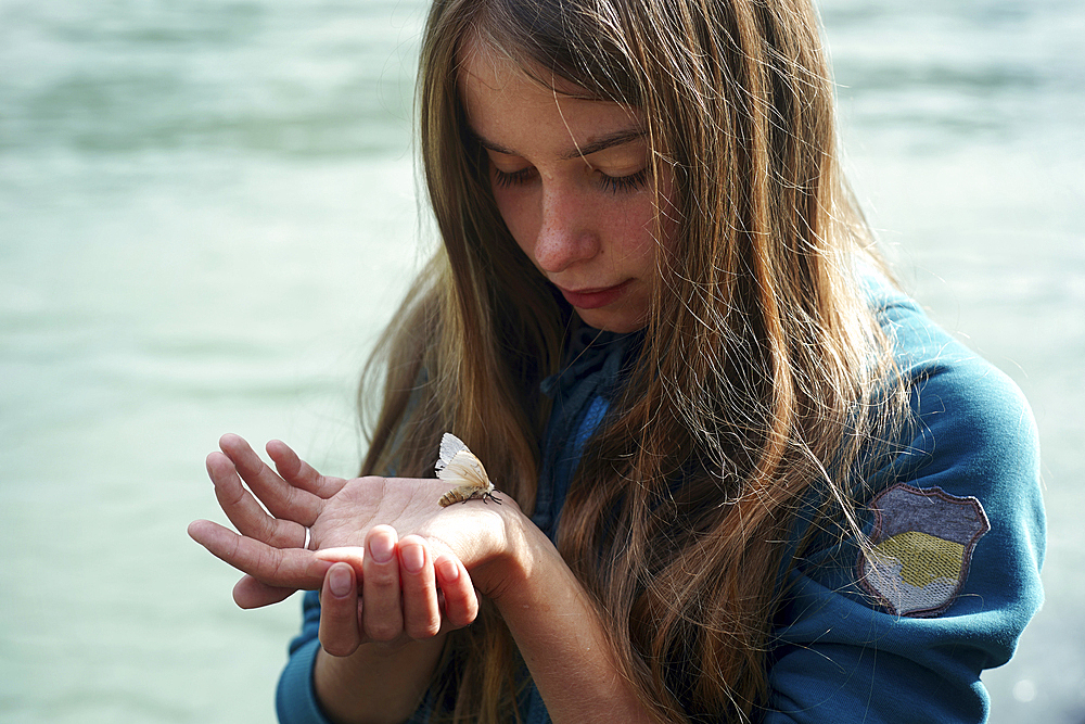 Caucasian girl watching moth on hand