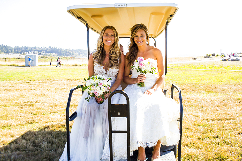 Caucasian brides sitting in golf cart